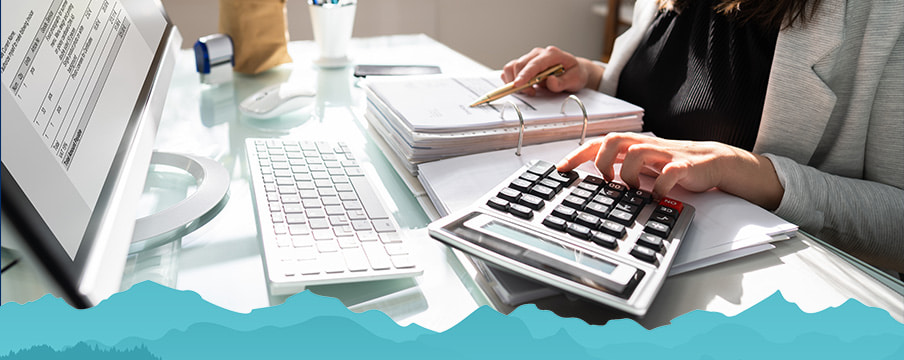 Woman going over taxes using a calculator 